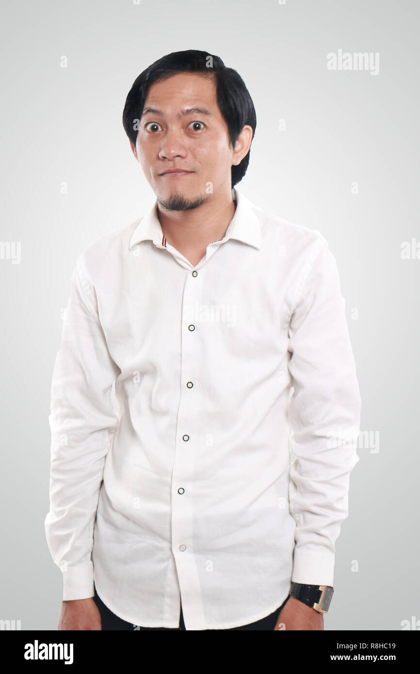 Photo image portrait of a funny young Asian businessman looking to camera, half body close up portrait with natural standing gesture Stock Photo