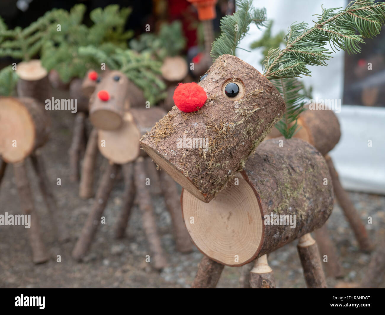 Decorative wooden log versions of Rudolph red nosed reindeer Christmas time Stock Photo