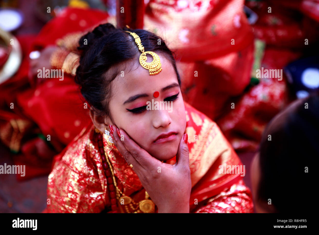 Kathmandu, Nepal, 15th December 2018. An adorned Newar girl in bridal dress seen performing ritual during the IHI ceremony. IHI also called Bel Bibaha is unique traditional ceremony practiced in Newar communities before puberty. In Newar community girls are married three times in their lives, first is IHI ceremony, which last for two days where girls are married to Lord VISHNU,  Second they are married to the Sun and finally with their real husband. Credit: SOPA Images Limited/Alamy Live News Stock Photo