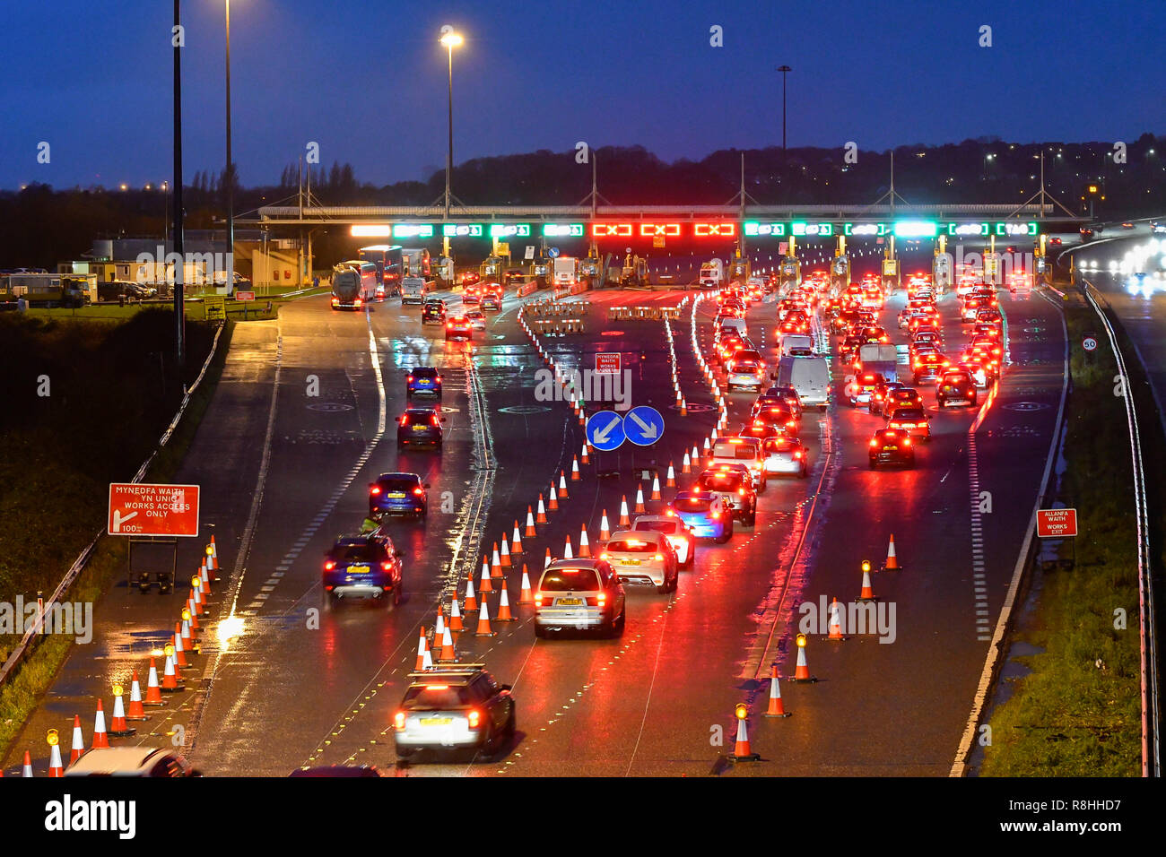 Severn Bridge, Wales, UK. 15th December 2018. Traffic queuing at dusk for the toll as work continues to remove three of the the Severn Bridge toll booths on the M4 Motorway in Wales, UK ahead of the tolls being scrapped from Monday 17th December when it will be free to cross the bridge. Picture Credit: Graham Hunt/Alamy Live News Stock Photo