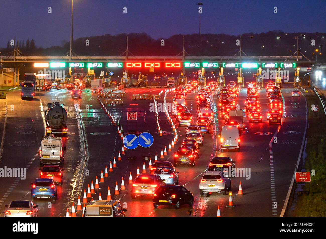 Severn Bridge, Wales, UK. 15th December 2018. Traffic queuing at dusk for the toll as work continues to remove three of the the Severn Bridge toll booths on the M4 Motorway in Wales, UK ahead of the tolls being scrapped from Monday 17th December when it will be free to cross the bridge. Picture Credit: Graham Hunt/Alamy Live News Stock Photo
