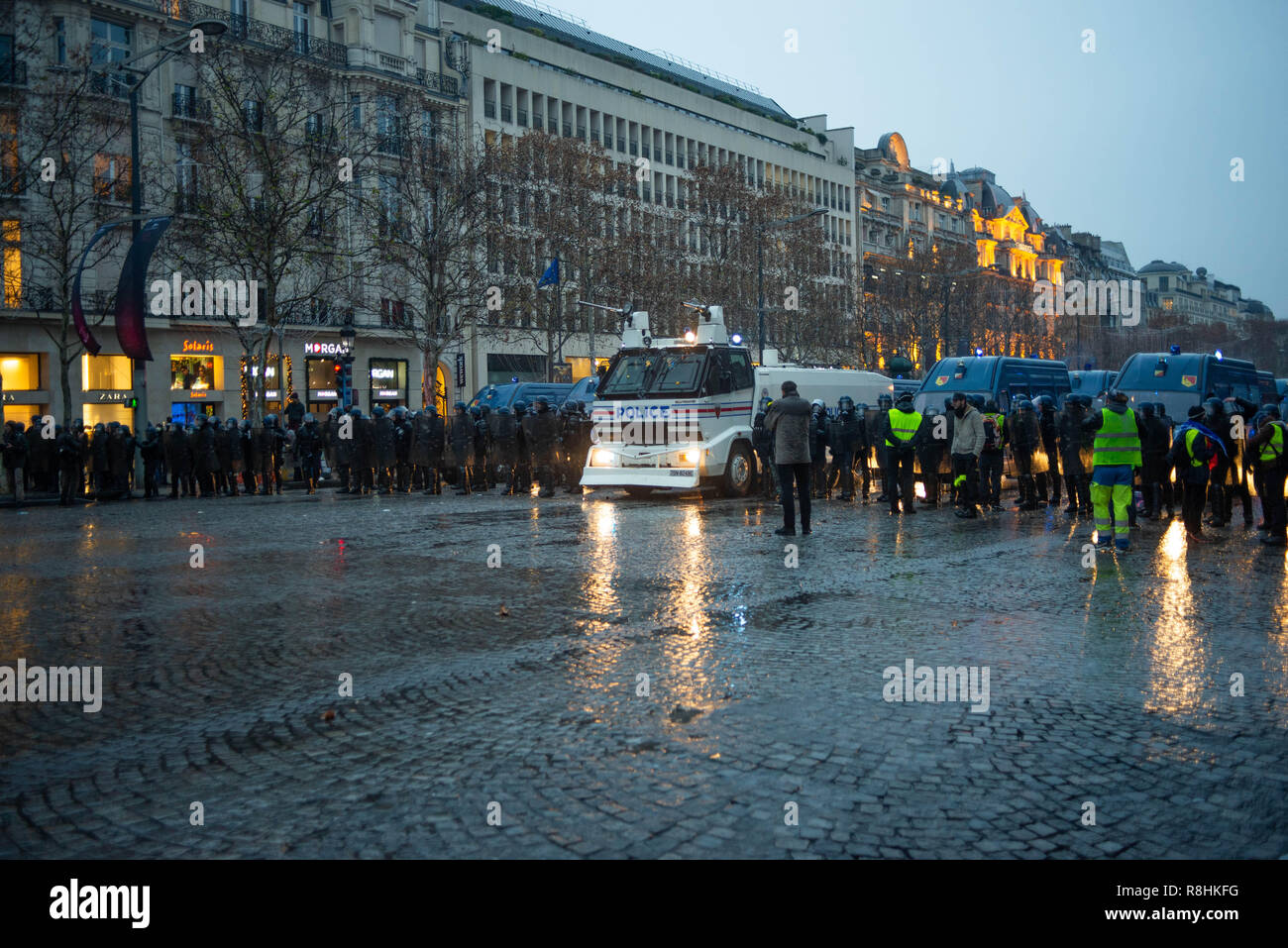 Paris, France. 15th December 2018. Police line with armored water tank and  several protestors. Yellow Vest (