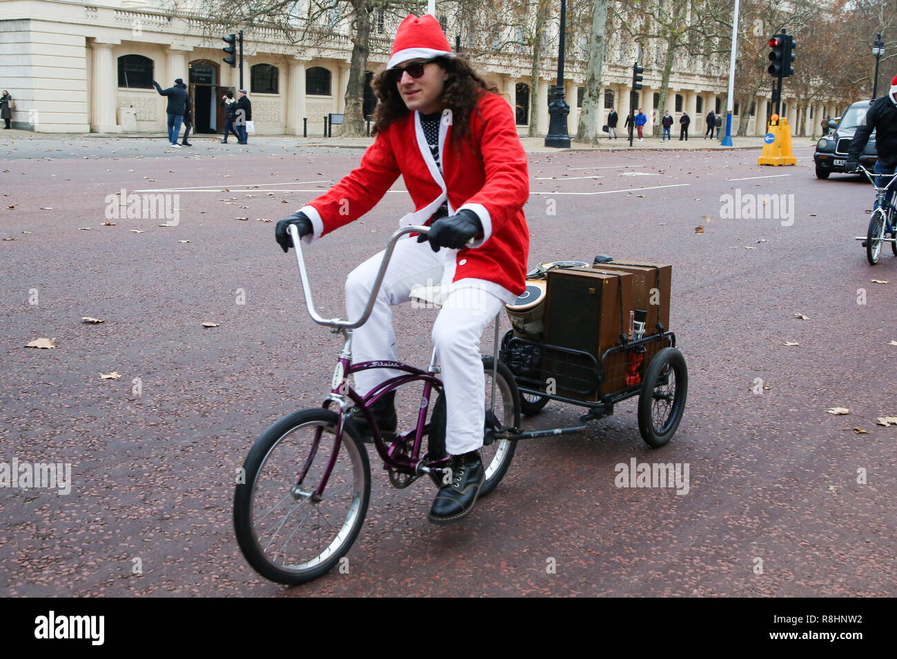 London, UK. 15th Dec, 2018. A man dressed as Father Christmas is seen on The Mall as he cycles during the event.Cycling through London to raise awareness and money for Evelina London Children's Hospital (ECHO), for children with heart conditions. The annual event began four years ago after Stephane Wright's son Tommy, suffered a heart attack and spent time at Evelina London. Tommy was only 6 months old when he suffered a heart attack and nearly died. Fortunately Tommy recovered well but will require further operations as he grows up, so will be returning to the Evelina Lond Stock Photo