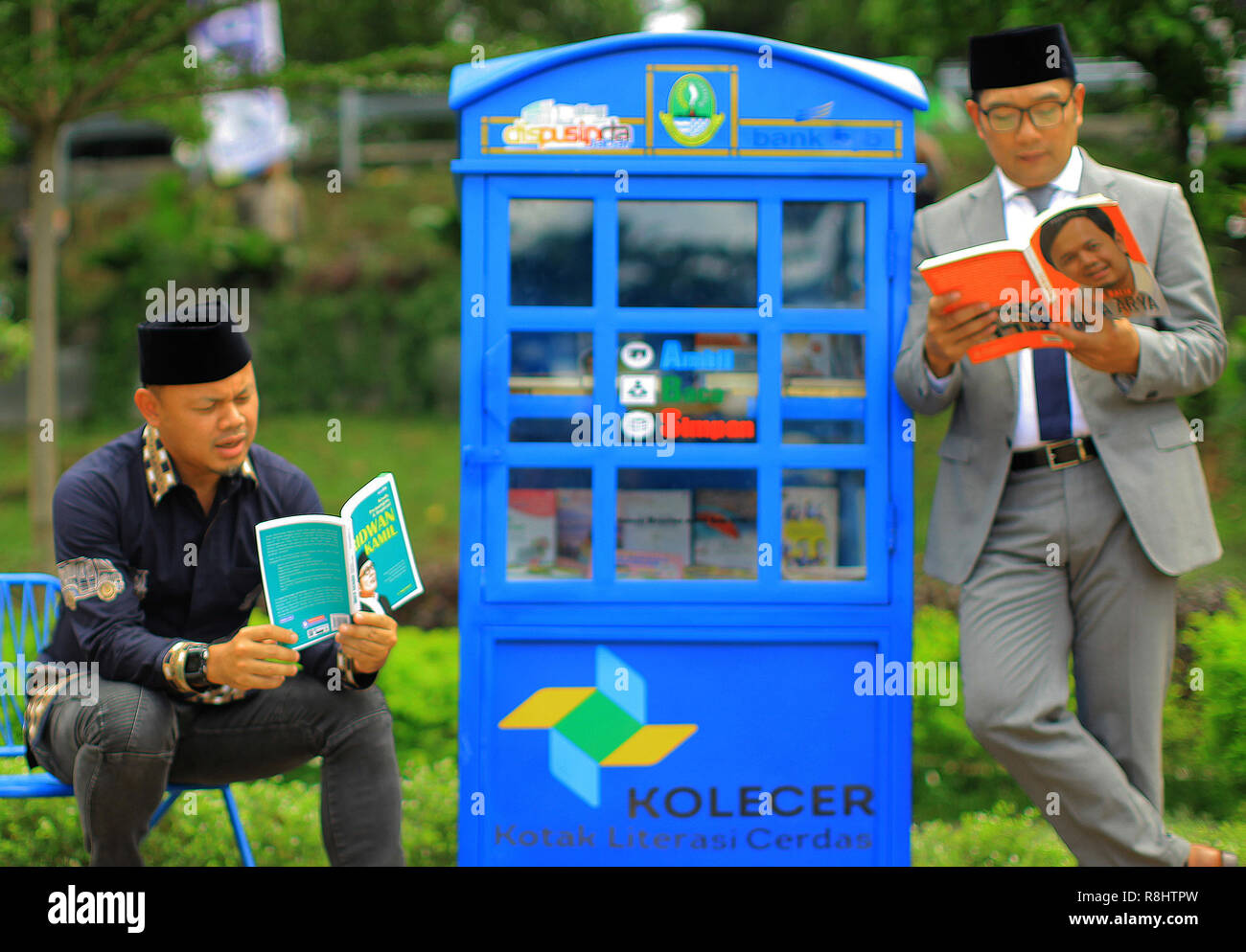 West Java Governor Ridwan Kamil (right) with Bogor Mayor Bima Arya (left) read a book during the launch of the Smart Literacy Box (Kolecer) service in Sempur Park. Kolecer, which was launched by the Regional Archives Library Office (Dispusipda) of West Java Province in the form of a mini library in a public space capable of loading 80 books as a form of innovation so that people can fill their time by reading. Stock Photo