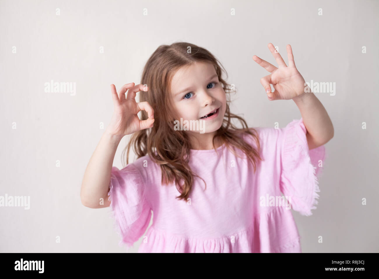 little girl in a pink dress shows hands heart Stock Photo - Alamy
