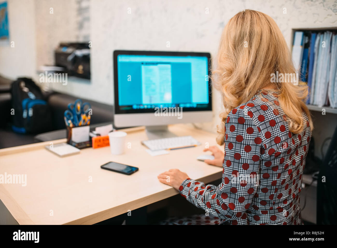 Female Business Person Sitting At The Desk And Works On Computer