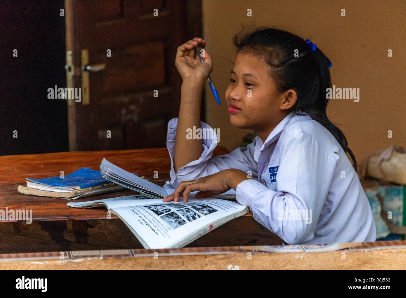 Thakhek, Laos - April 20, 2018: Young girl reading a book and dreaming about the future Stock Photo