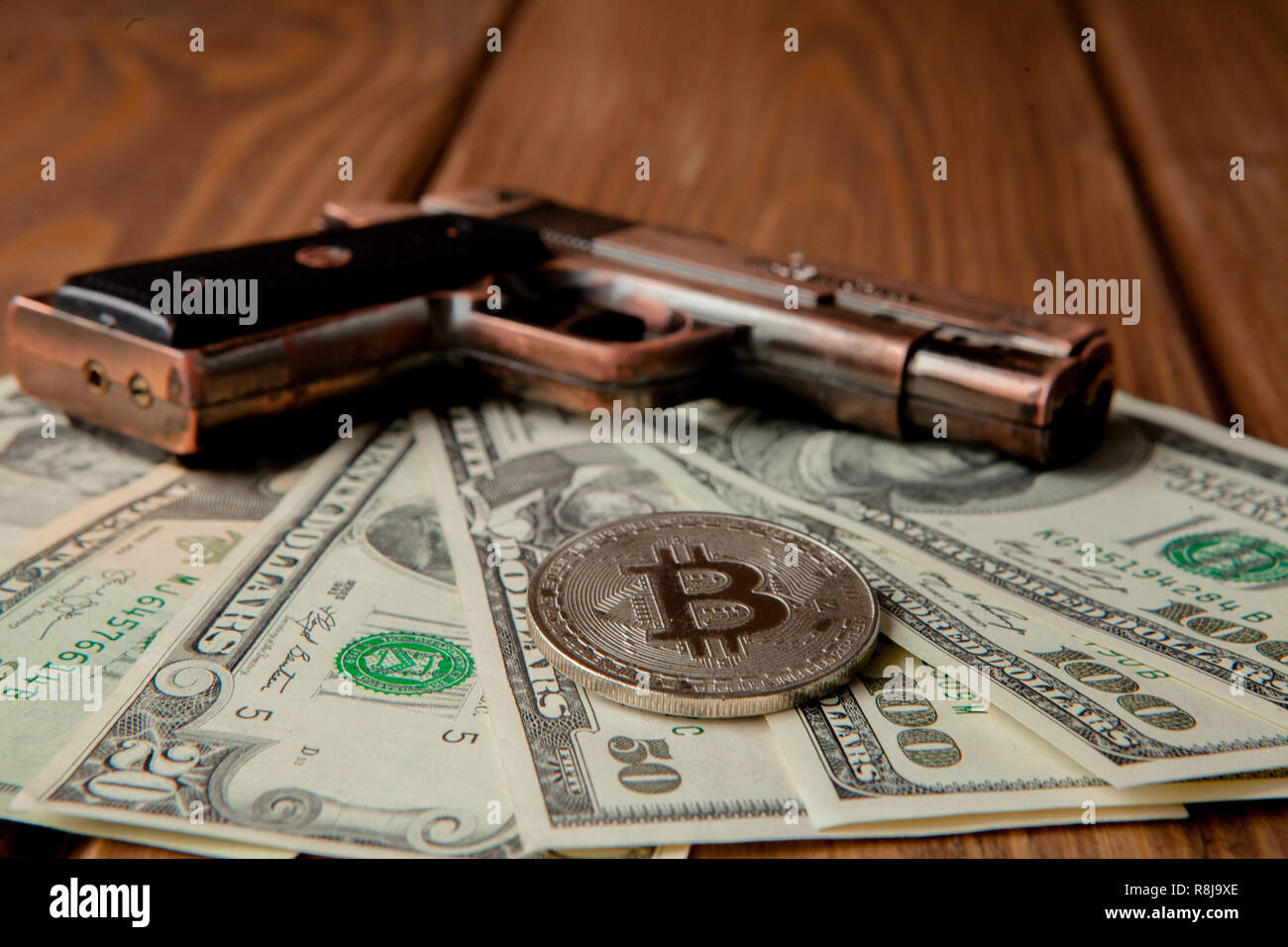 Black pistol, dollars and coin in the form of bitcoin on wooden background  Stock Photo - Alamy