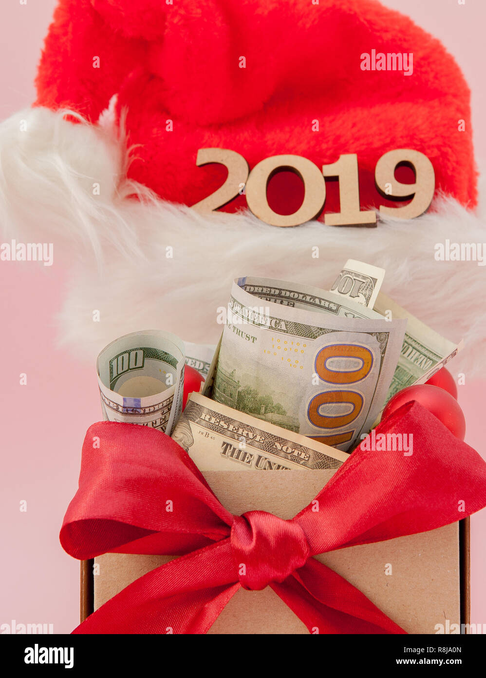 New year gift box with dollars and inscription 2019 on a pink
