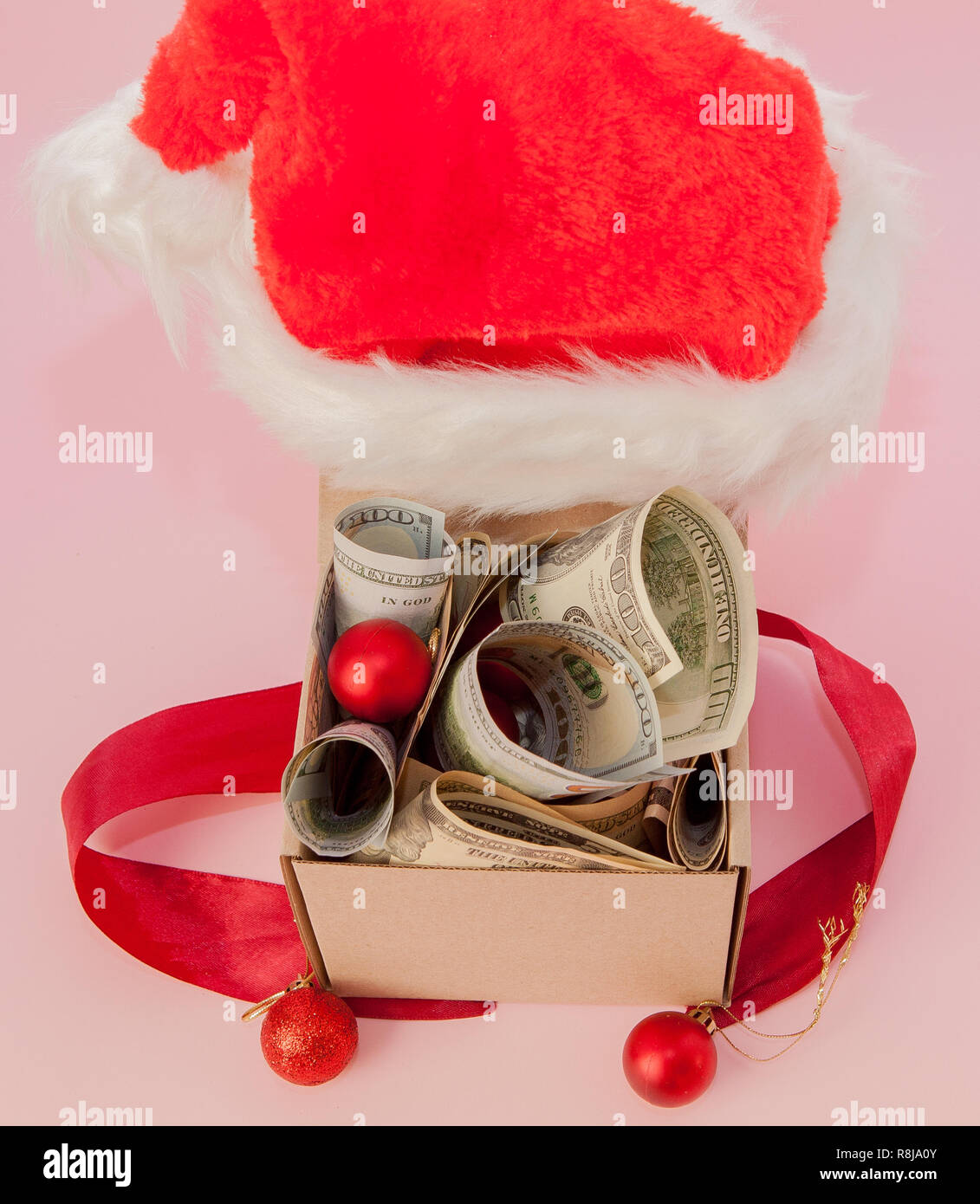 New year gift box with dollars on pink background close up Stock Photo