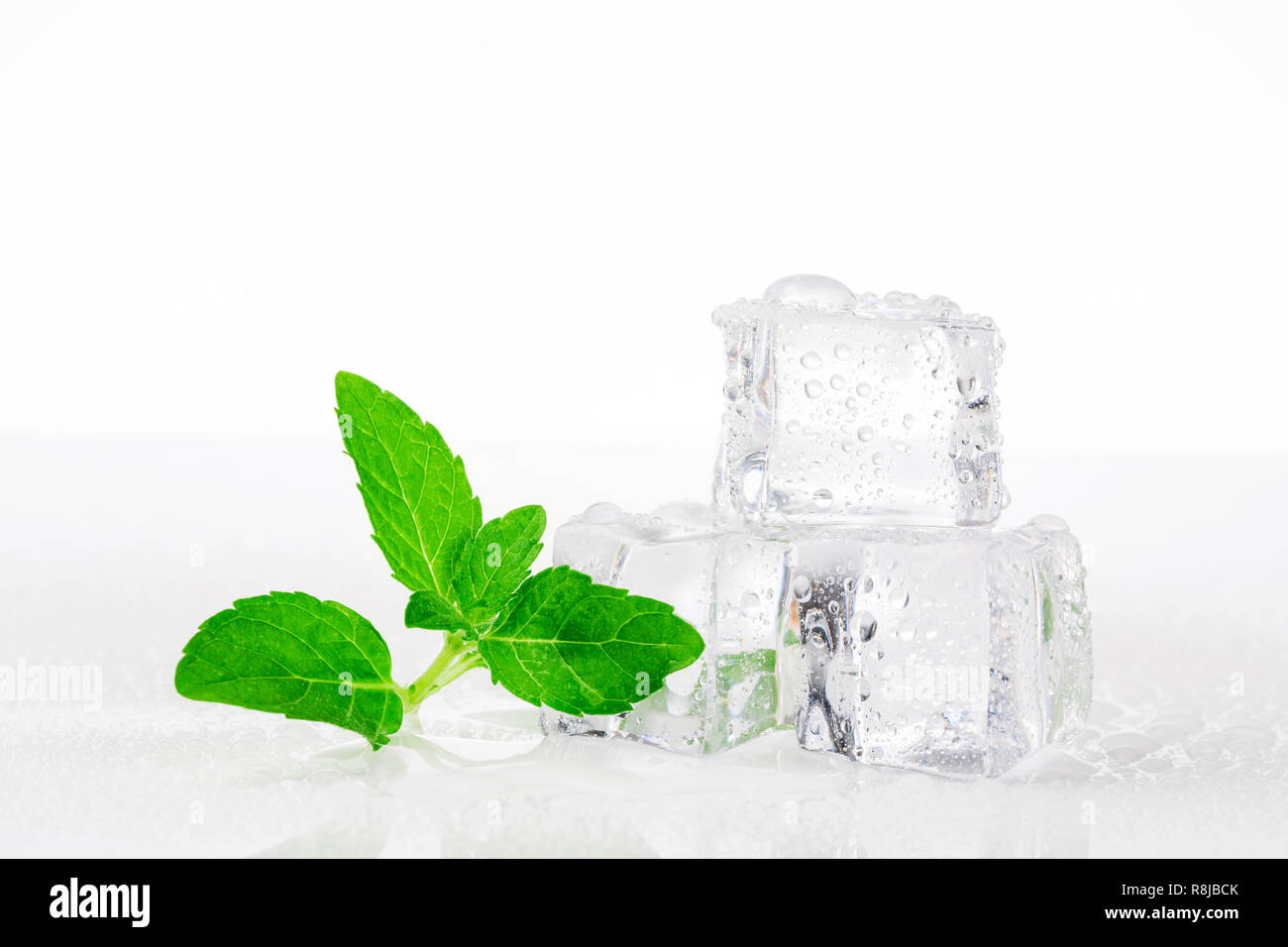 Ice cubes with mint leaves on white background Stock Photo