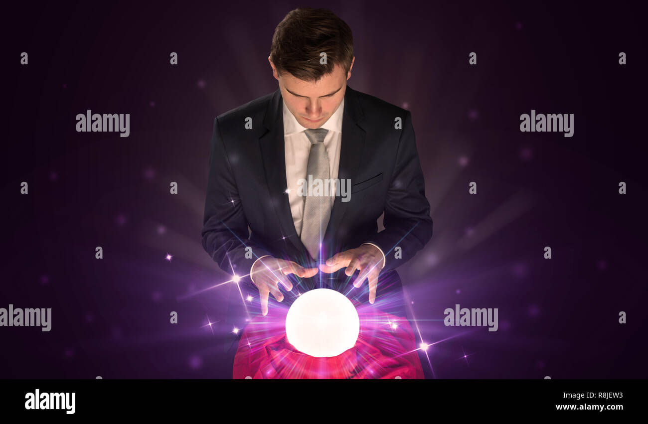 Young businessman sitting with crystal ball in action Stock Photo - Alamy