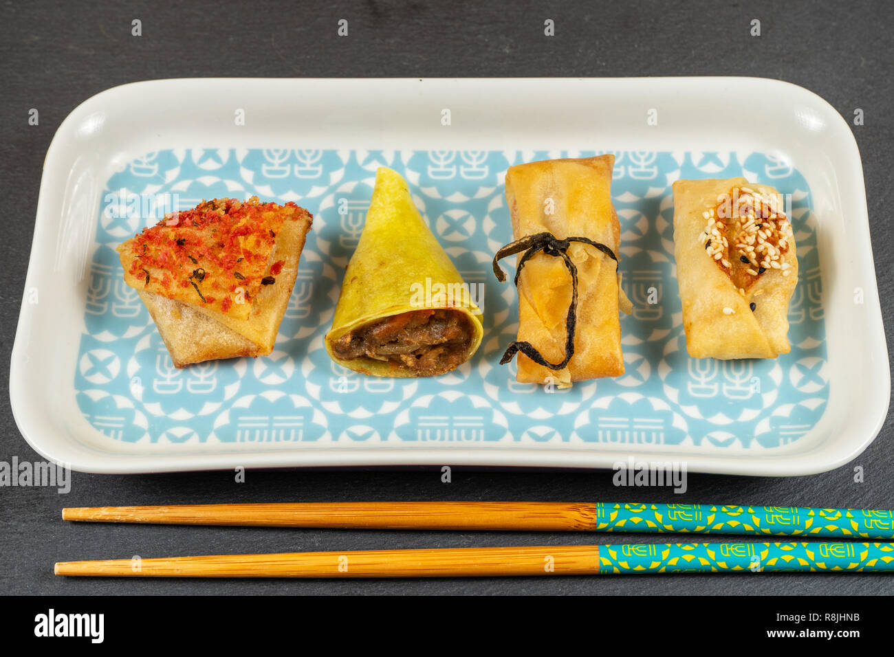 Asian food selection.Duck cones,parcels,baskets with ginger and soy sauce,tikka crackers,massaman windmills Stock Photo