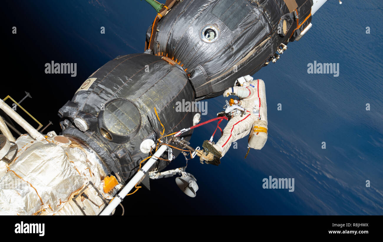 Russian spacewalker Oleg Kononenko attached to the Strela boom inspect the Soyuz MS-09 spacecraft docked to the International Space Station December 11, 2018 in Earth Orbit. During the spacewalk, he and fellow spacewalker Sergey Prokopyev, examined the external hull of the Soyuz crew ship docked to the Rassvet module. The area corresponded with the location of a small hole inside the Soyuz habitation module that was found in August and caused a decrease in the space station’s pressure. The hole was fixed internally with a sealant within hours of its detection. During the spacewalk, Kononenko a Stock Photo