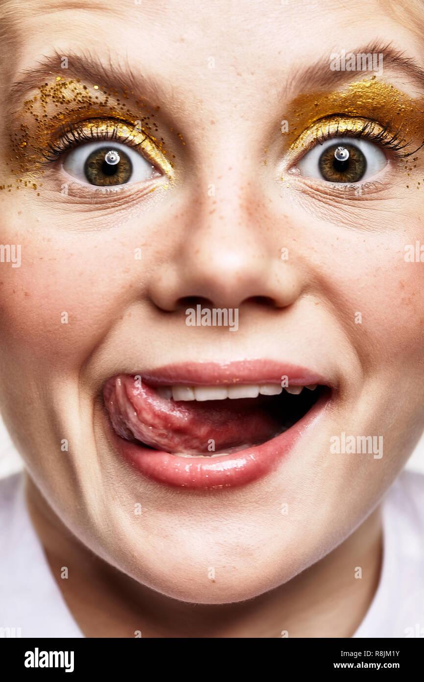 Close-up shot of smiling joyful female face. Portrait of a young woman. Girl with an unusual makeup and happy face expression. Stock Photo