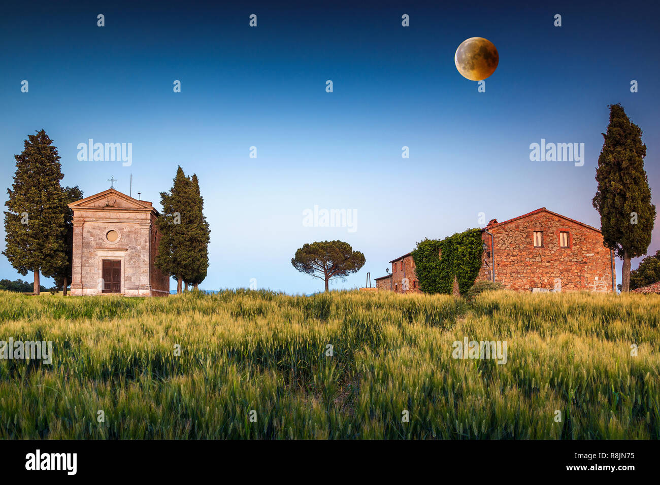 Fantastic photography place in Tuscany, famous Vitaleta chapel in spring with spectacular full moon at colorful sunset, Pienza, Tuscany, Italy, Europe Stock Photo