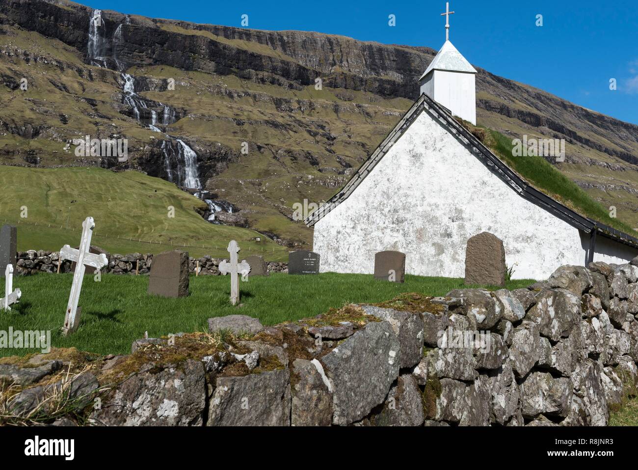 Denmark, Faroe Islands, Streymoy Island, Saksun, church with turf roof and waterfall in the background Stock Photo