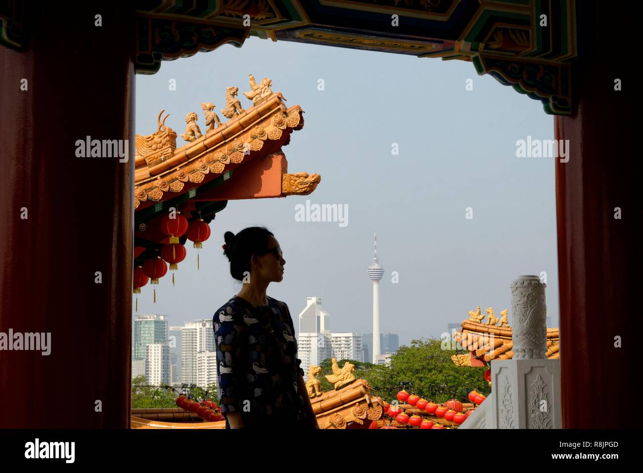Malaysia, Selangor State, Kuala Lumpur, woman at Thean Hou Chinese Temple, KL tower (Menara Kuala Lumpur) in the background Stock Photo
