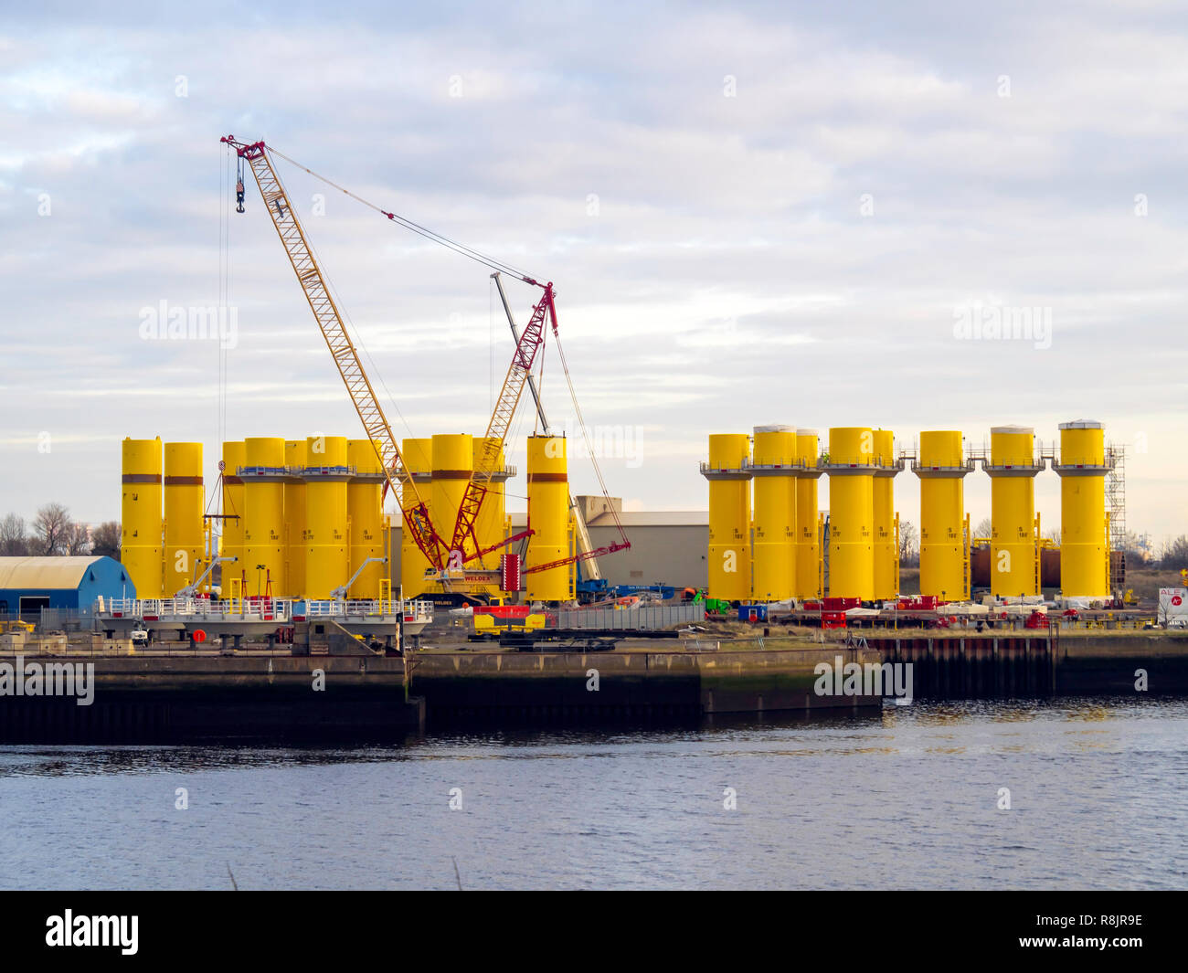 Offshore wind turbine transition pieces under construction  on the quayside at Wilton Group fabrication yard at Port Clarence on the River Tees Stock Photo