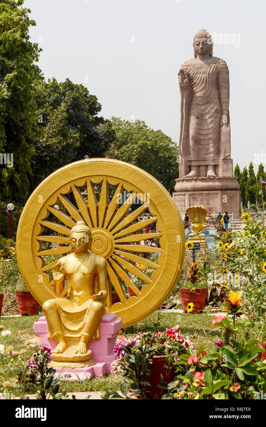 India, Uttar Pradesh, Sarnath, the thai temple, dharmachakra, dharma wheel one of the buddhist symbols and Lord Buddha standing statue Stock Photo