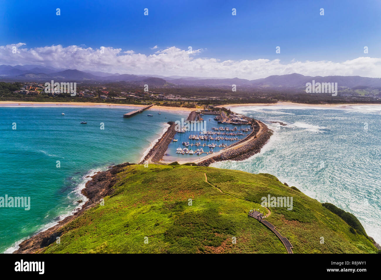 Coffs harbour town waterfront from Muttonbird island connected to shore by stone wave breaking wall protectin marina and local sandy beach. Stock Photo