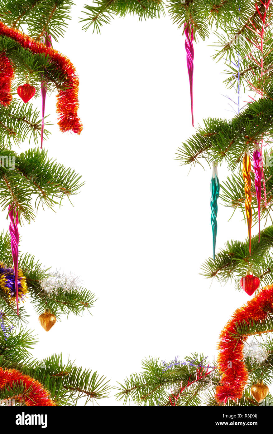 Colorful Christmas themed frame made from fir tree branches decorated with Christmas ornaments on white background Stock Photo