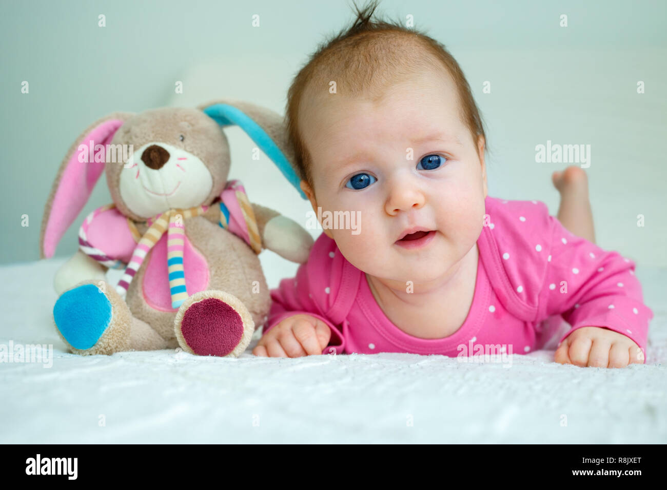 Portrait of a cute newborn baby girl lying on her stomach Stock Photo