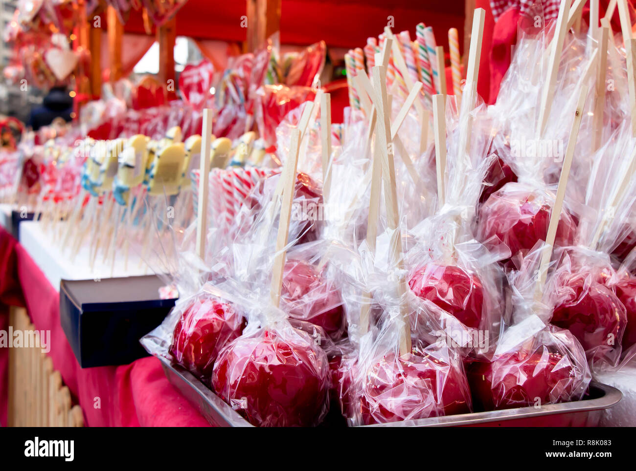 Red glazed candy apples wrapped in cellophane on display in Christmas street fair market Stock Photo