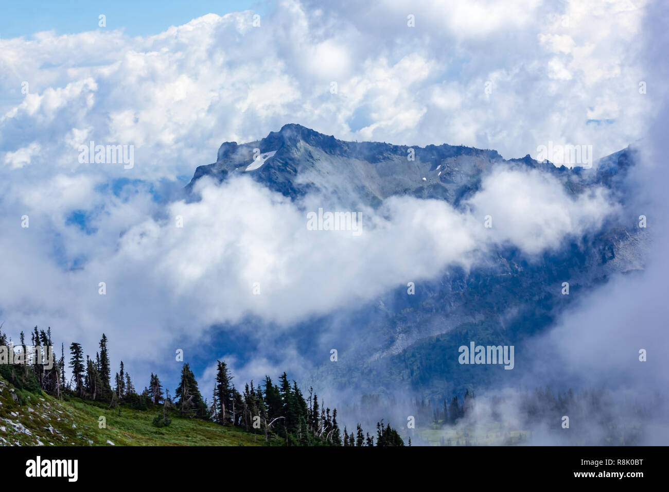 large mountains covered in dense cloud and fog Stock Photo