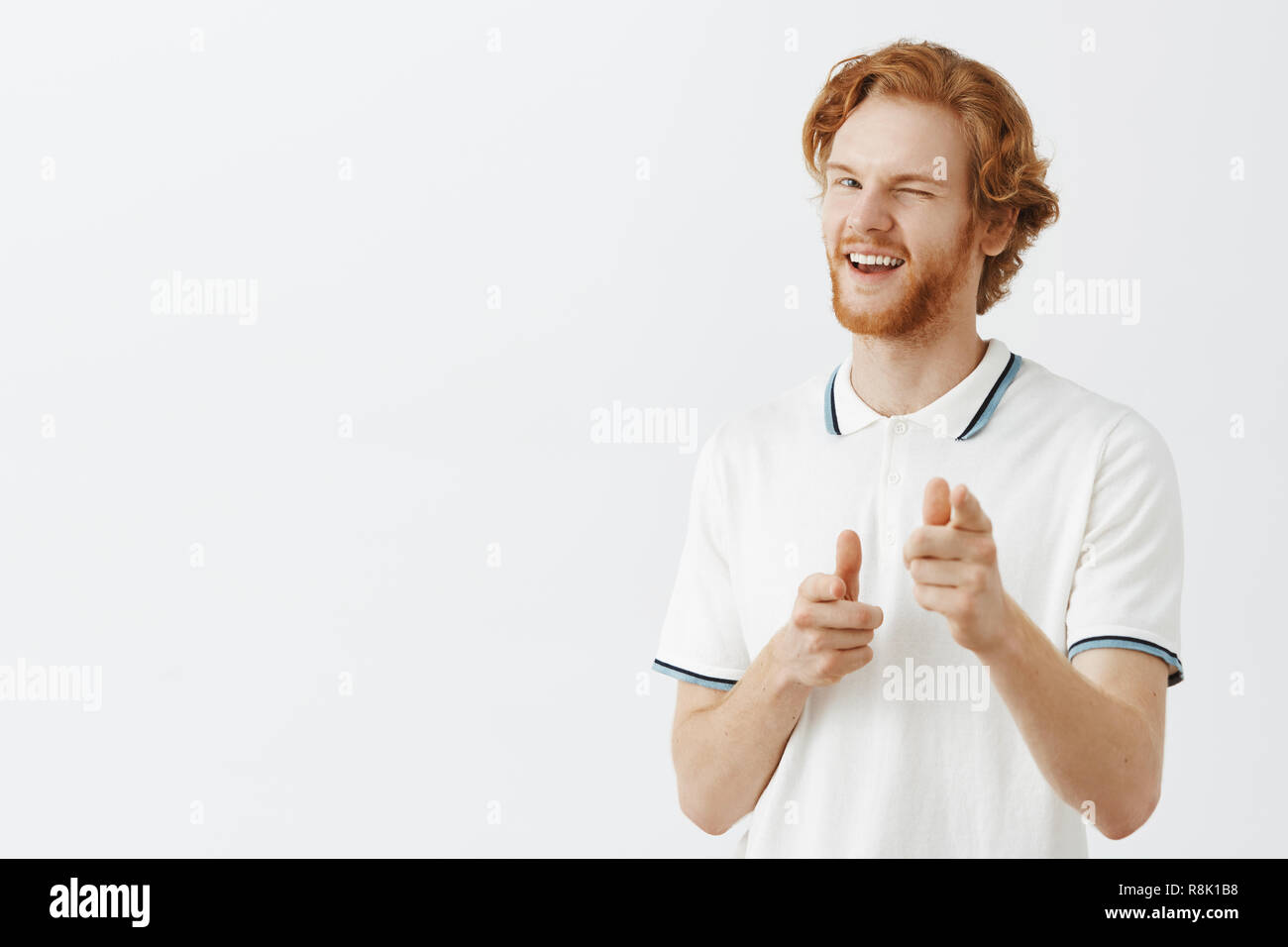 hey how you doing portrait of charming flirty and confident happy redhead guy with beard in white polo shirt pointing at camera with finger guns and winking with broad macho smile over hey how you doing portrait of charming flirty and confident happy redhead guy with beard in white polo shirt pointing at camera with finger guns and winking with broad macho smile over