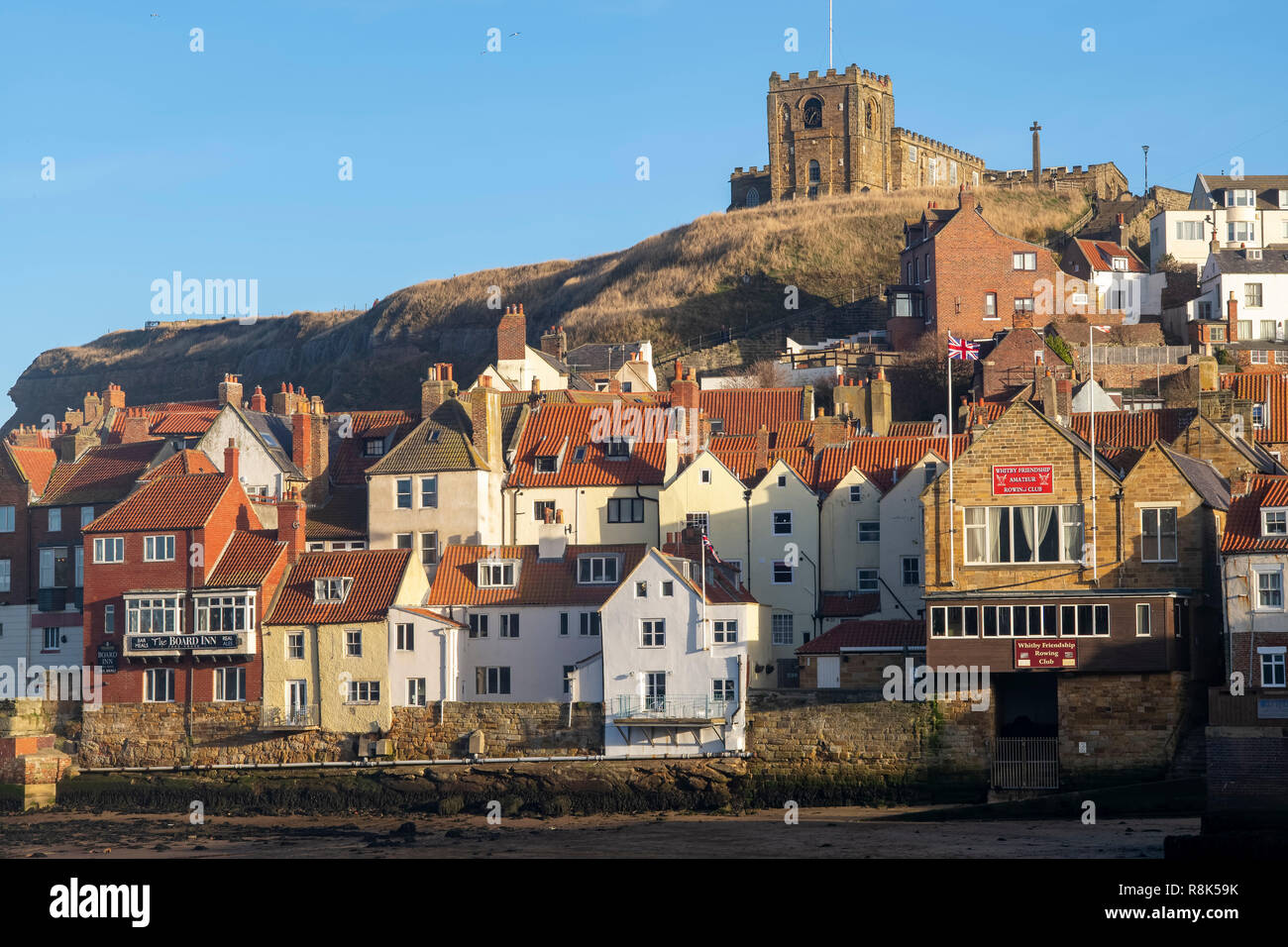 Winter sunlight on St Mary's Church and the red pantile roofs of  the Old Town Quarter, Whitby, North Yorkshire, UK Stock Photo