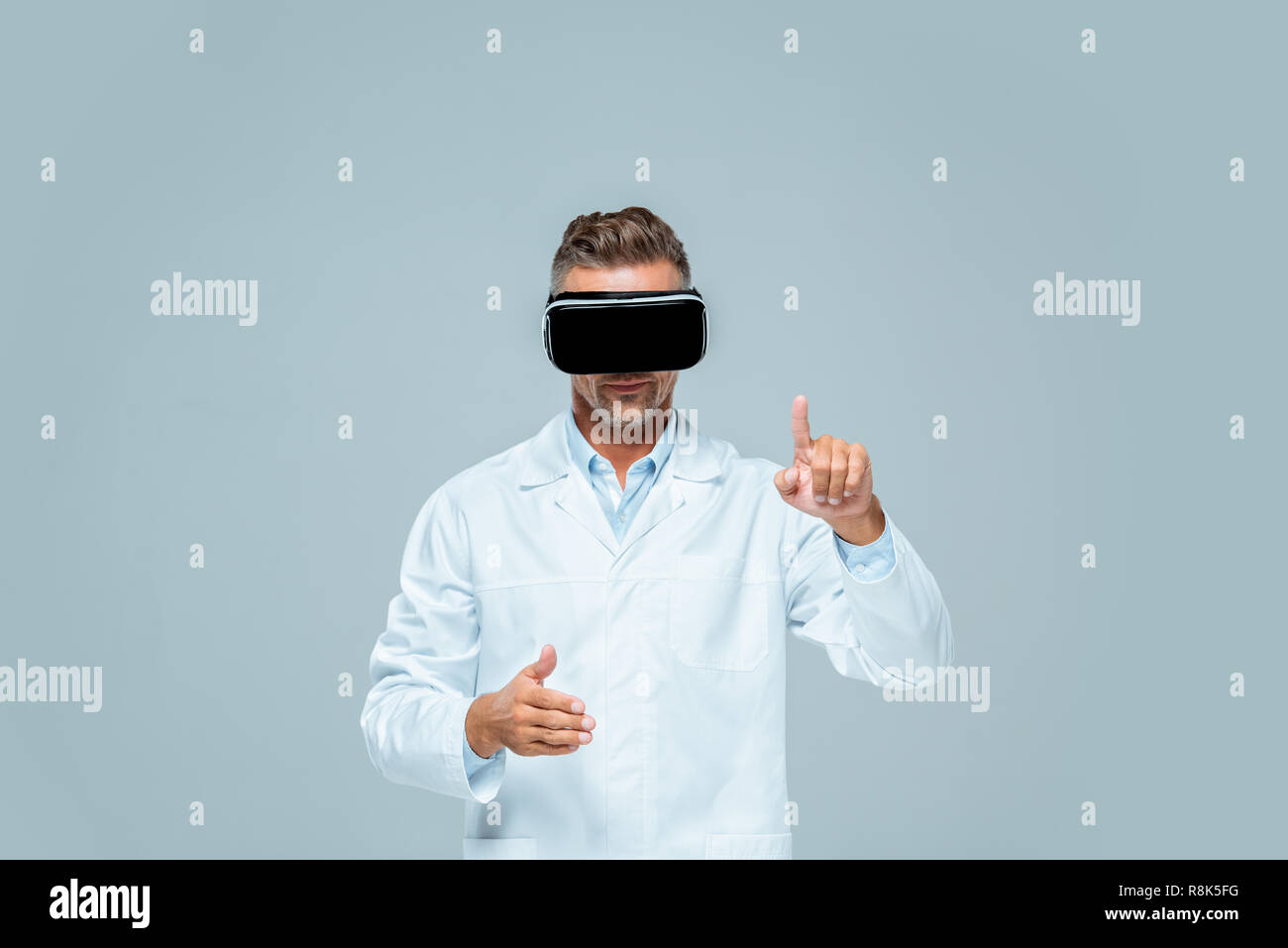scientist in virtual reality headset moving something isolated on grey, artificial intelligence concept Stock Photo