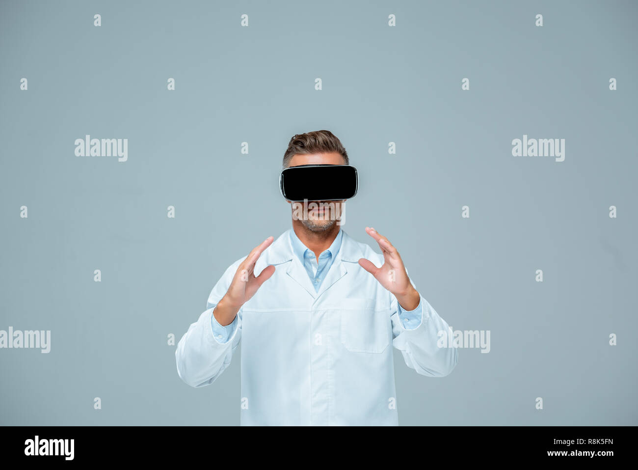 scientist in virtual reality headset holding something isolated on grey, artificial intelligence concept Stock Photo