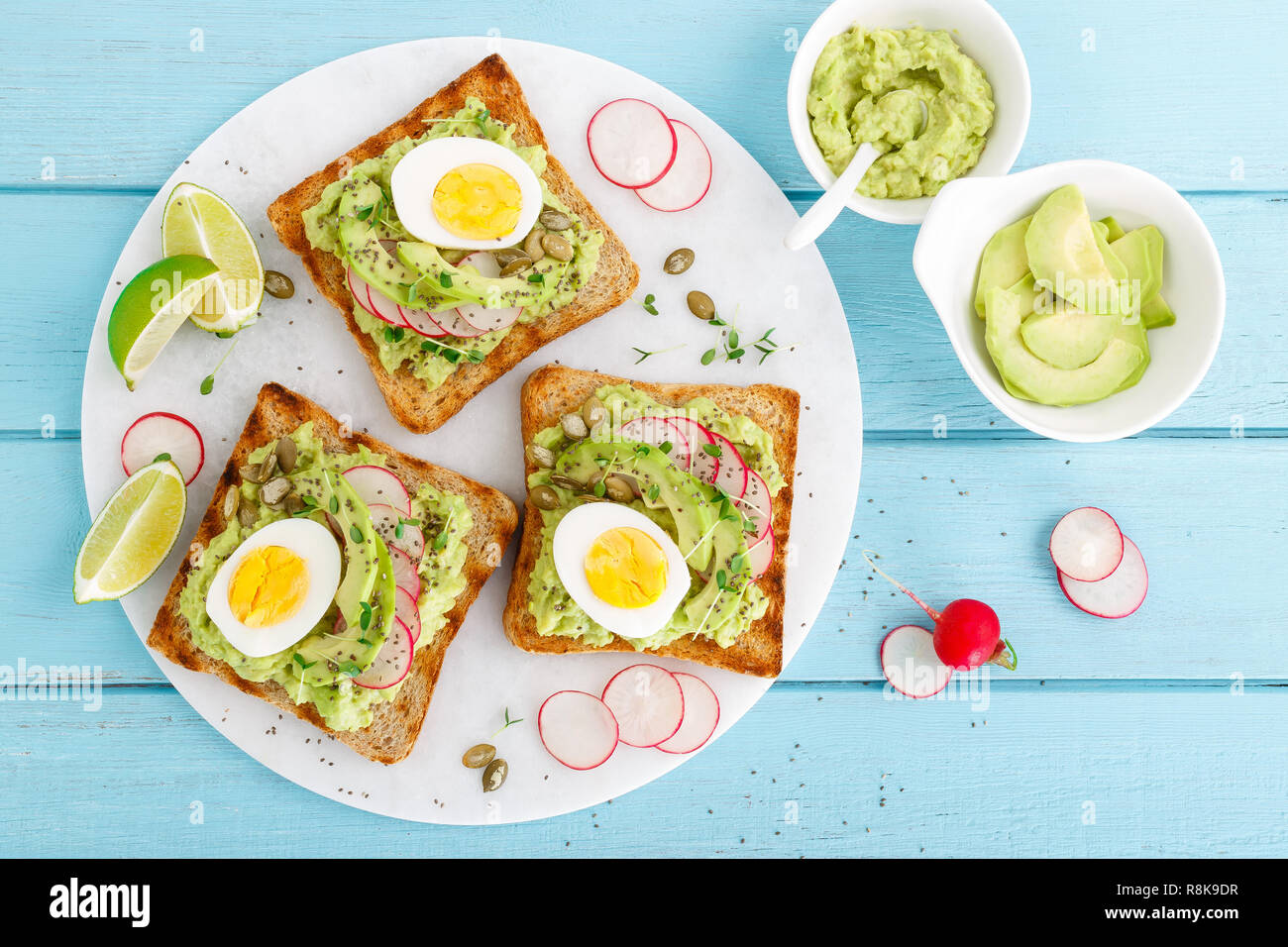Toasts with avocado guacamole, fresh radish, boiled egg, chia and