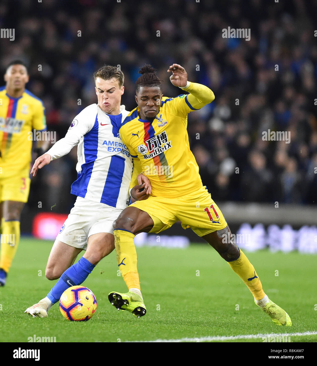 Solly March of Brighton tackles Wilfred Zaha of Crystal Palace during the Premier League match between Brighton & Hove Albion and Crystal Palace at the Amex Stadium . 04 December 2018 Editorial use only. No merchandising. For Football images FA and Premier League restrictions apply inc. no internet/mobile usage without FAPL license - for details contact Football Dataco Stock Photo