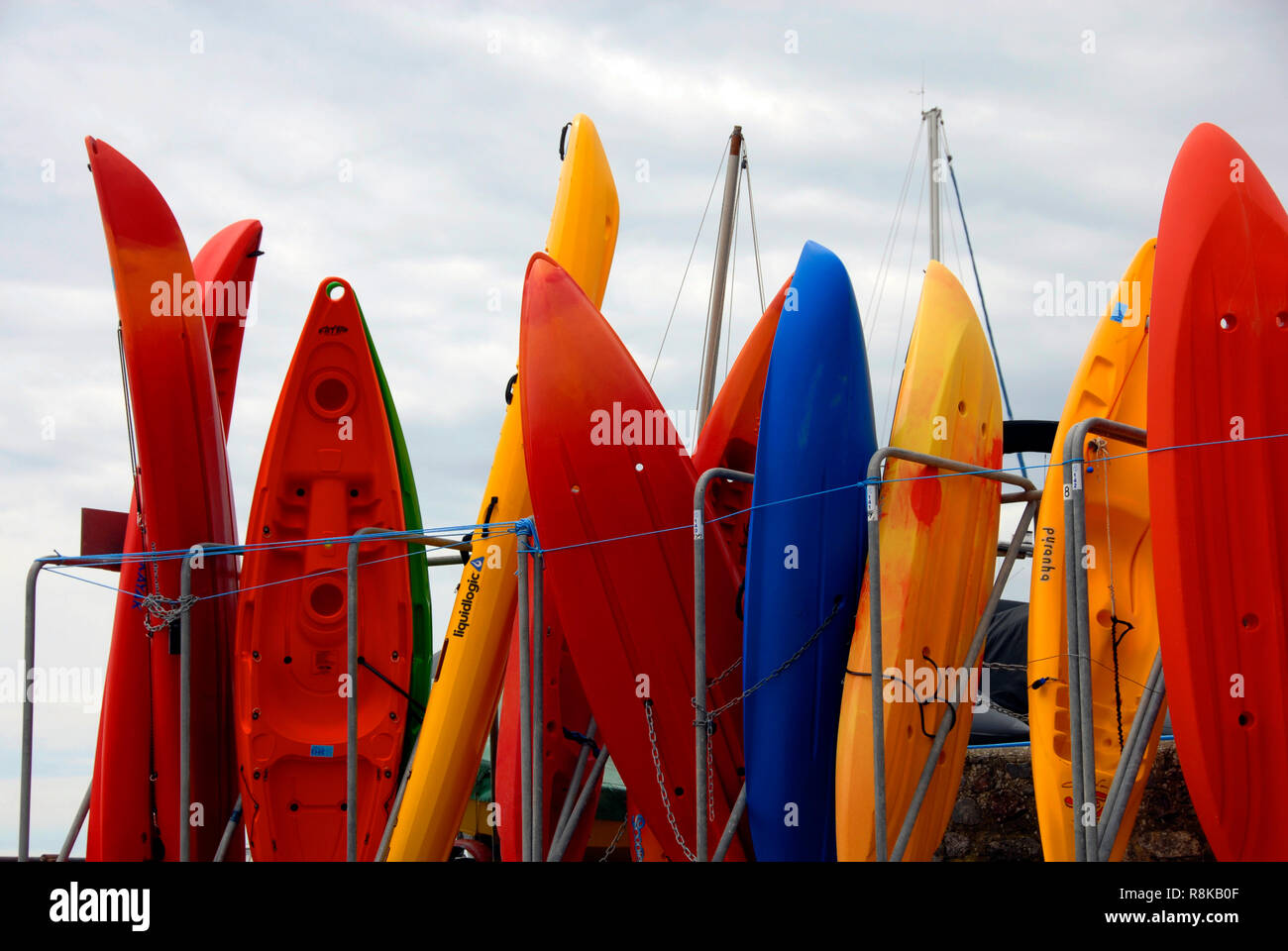 Surf boards in various colors in store on shore, Lyme Regis, Dorset, England Stock Photo