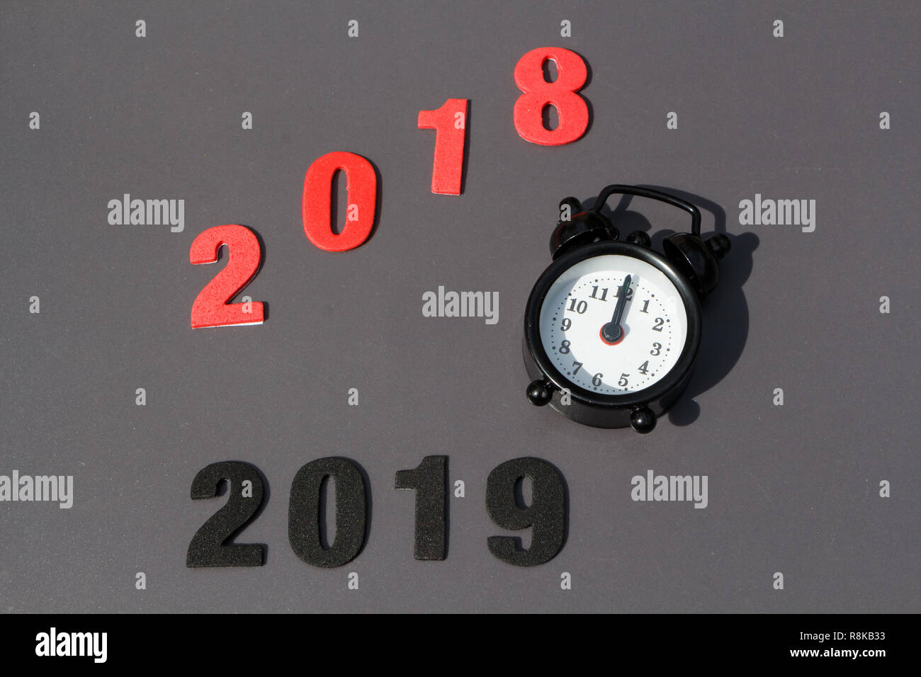2018, 2019 and black vintage alarm clock on gray background Stock Photo