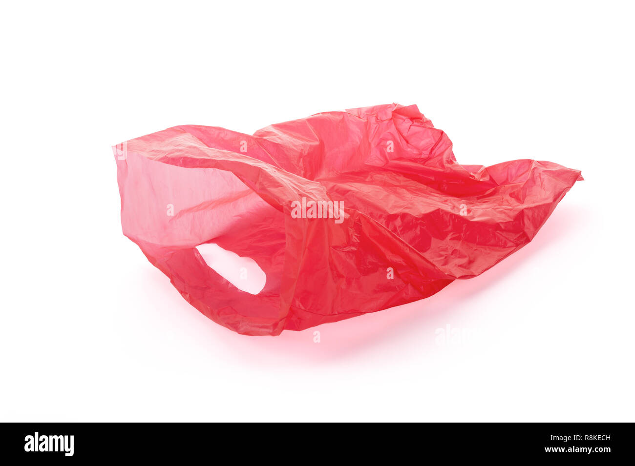 Floating empty red plastic garbage bag isolated on white background, clipping path around the bag, not around the cast shadow, included. Stock Photo