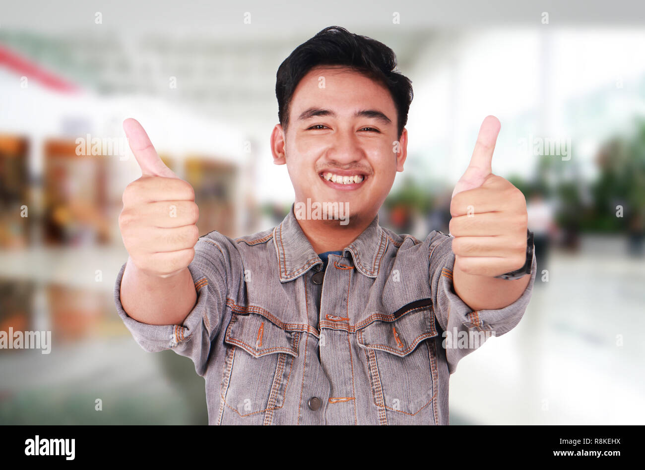 Photo image portrait of a cute young Asian man smiling and showing two ...