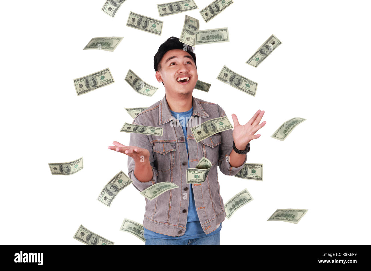 Photo image portrait of a cute young successful Asian male under rain of money, isolated on white Stock Photo