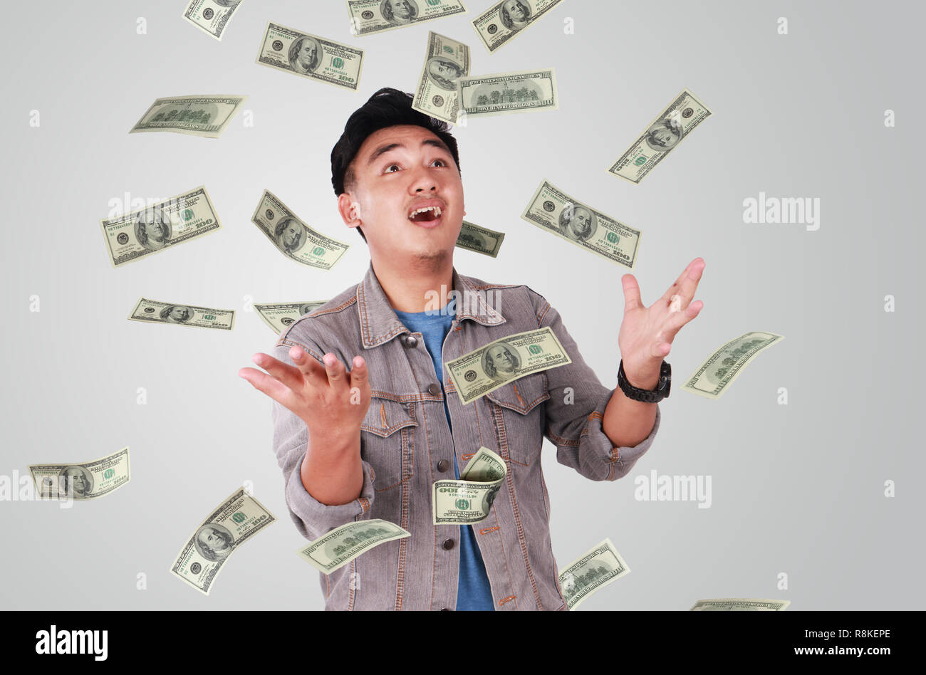 Photo image portrait of a cute young successful Asian male under rain of money Stock Photo