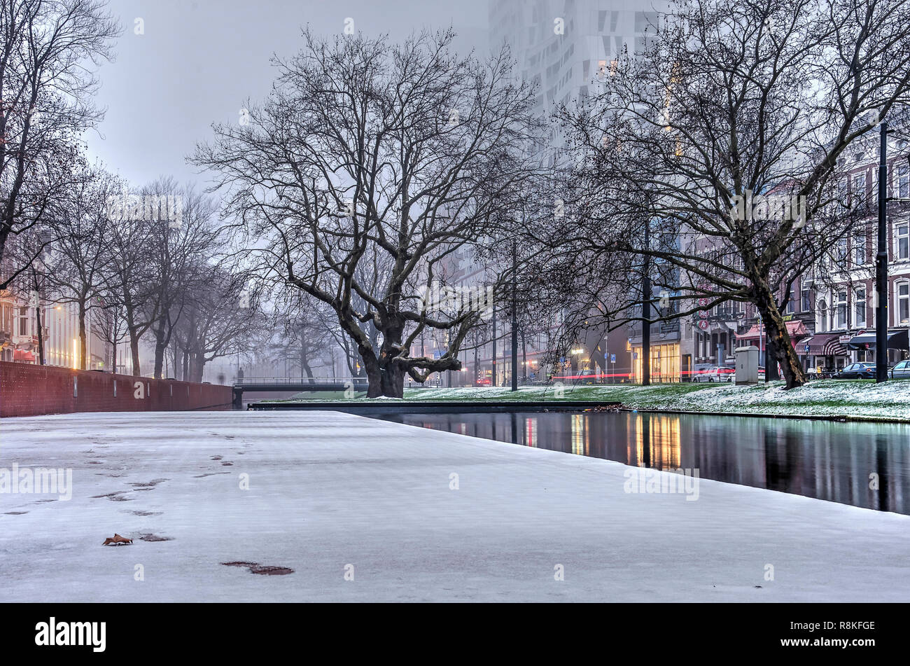 Rotterdam, The Netherlands, December 16, 2018: a thin and short lived layer of snow on the quay of Westersingel canal, with old and new buildings and  Stock Photo