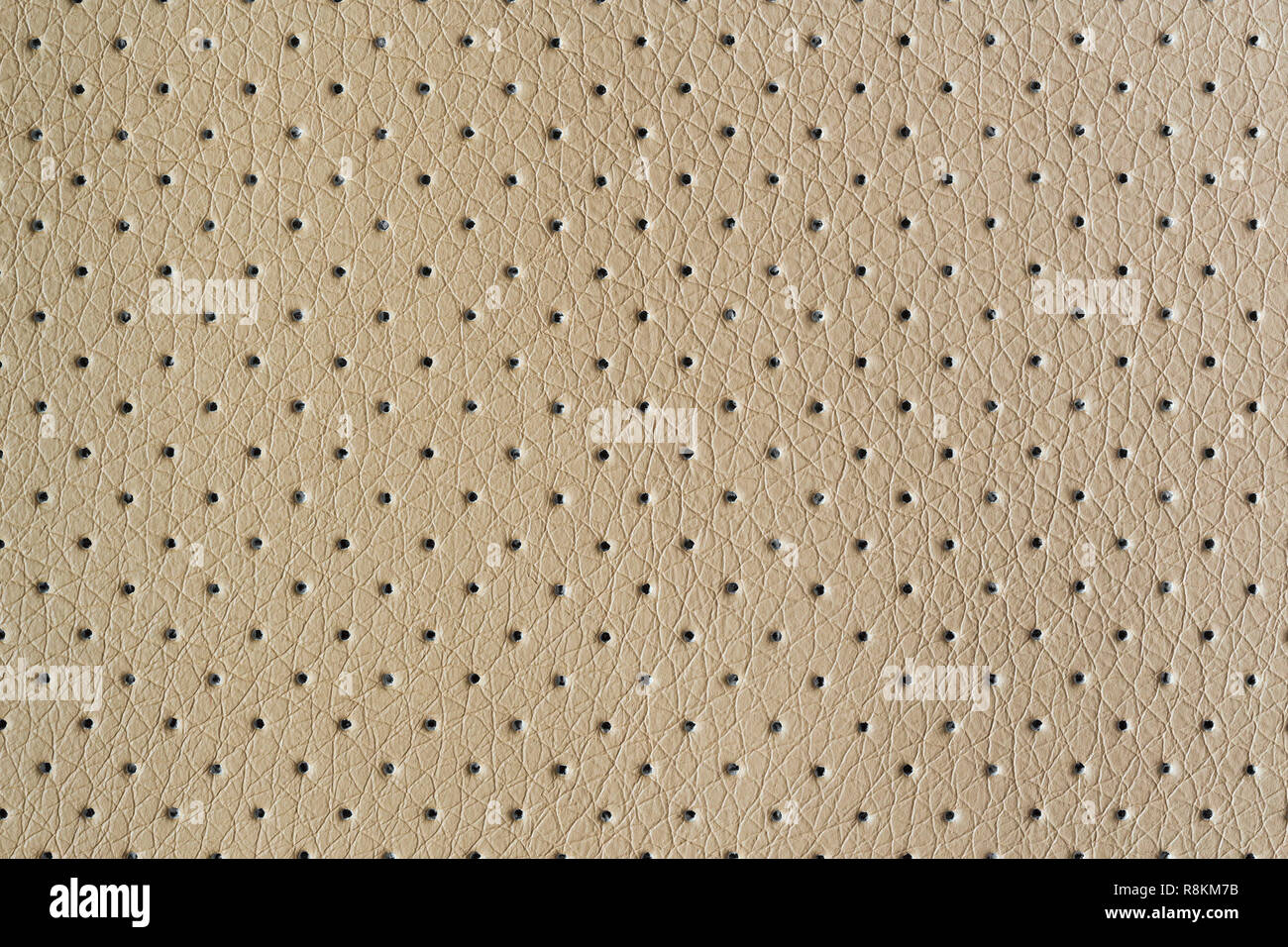Beige perforated eco leather with embossed closeup Stock Photo