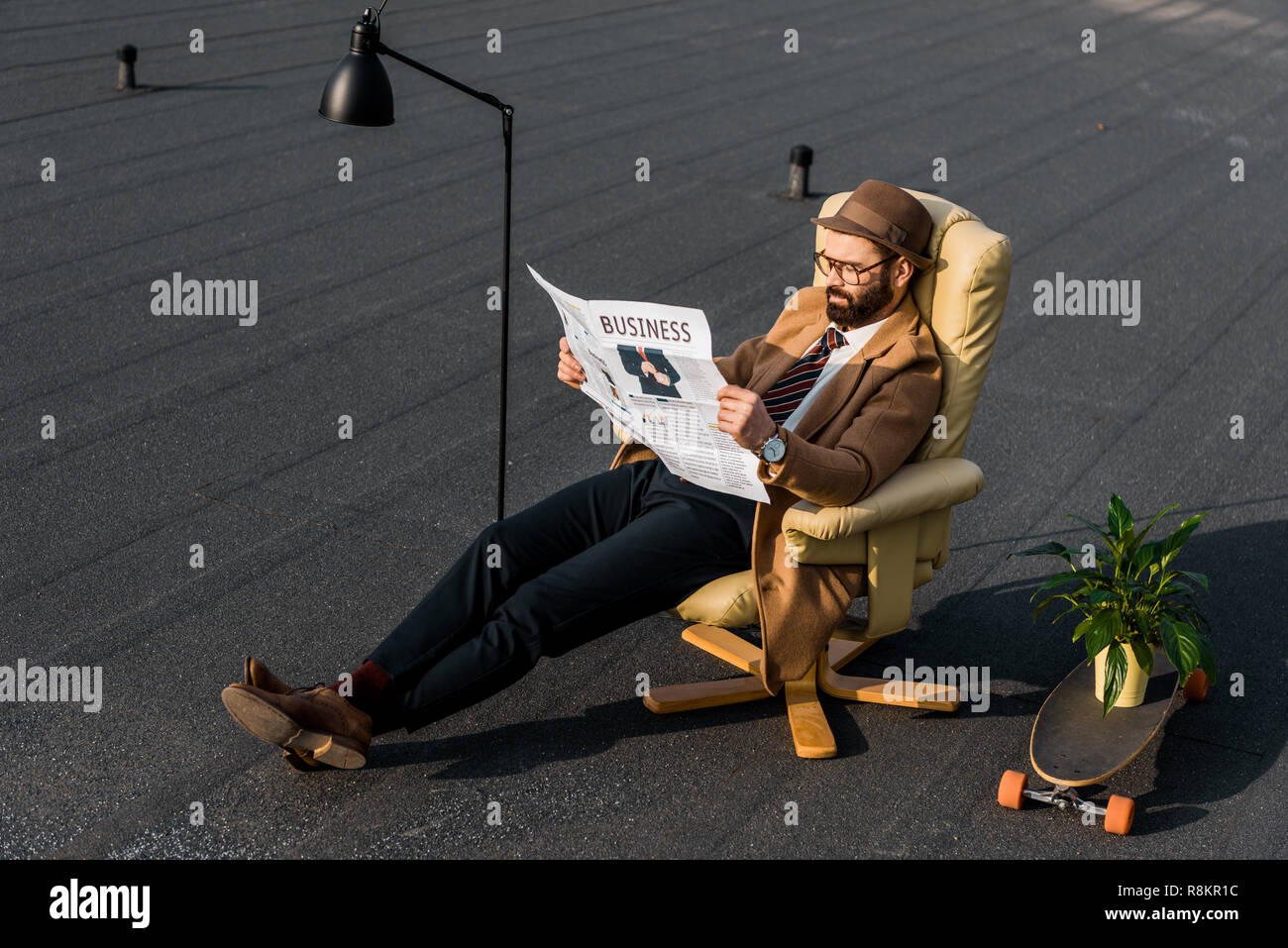 bearded man in coat reading business newspaper in armchair Stock Photo ...