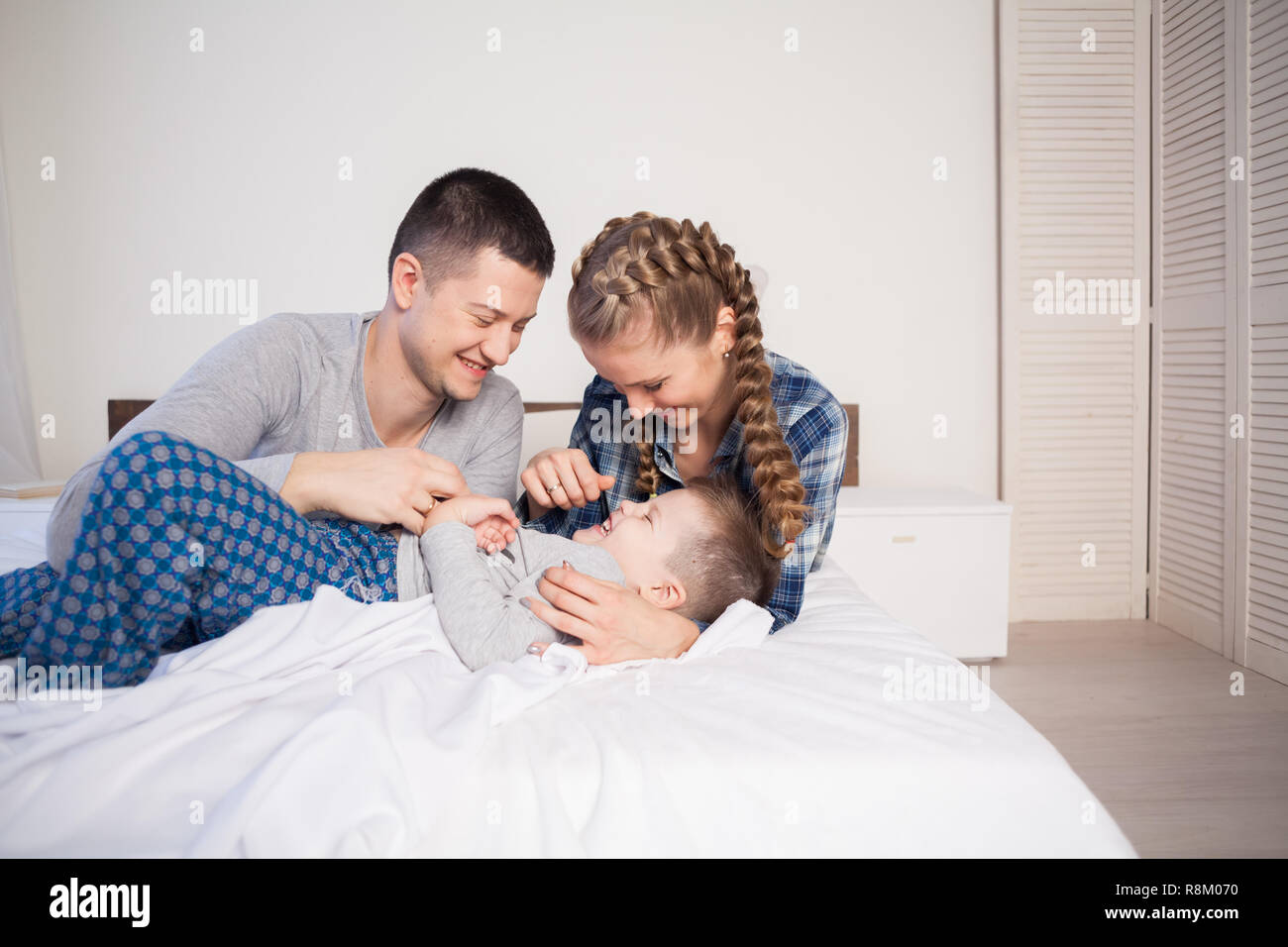 The Family Morning In The Bedroom On The Bed Mom Dad Son Stock