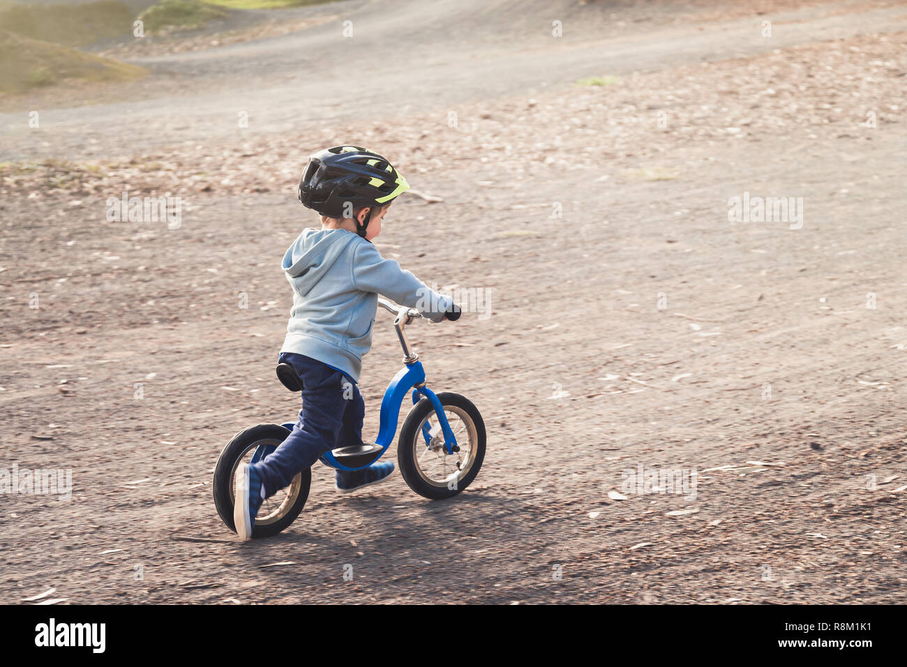 Australian kid riding his balance bike in the park, South Australia Stock Photo
