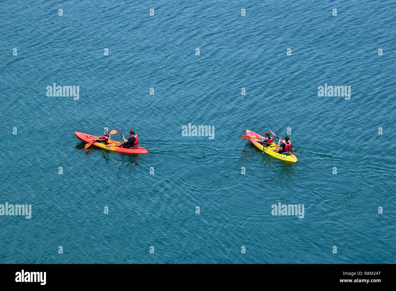 Children kayaking with adults, just outside Gorren Haven Harbour, Cornwall, UK Stock Photo