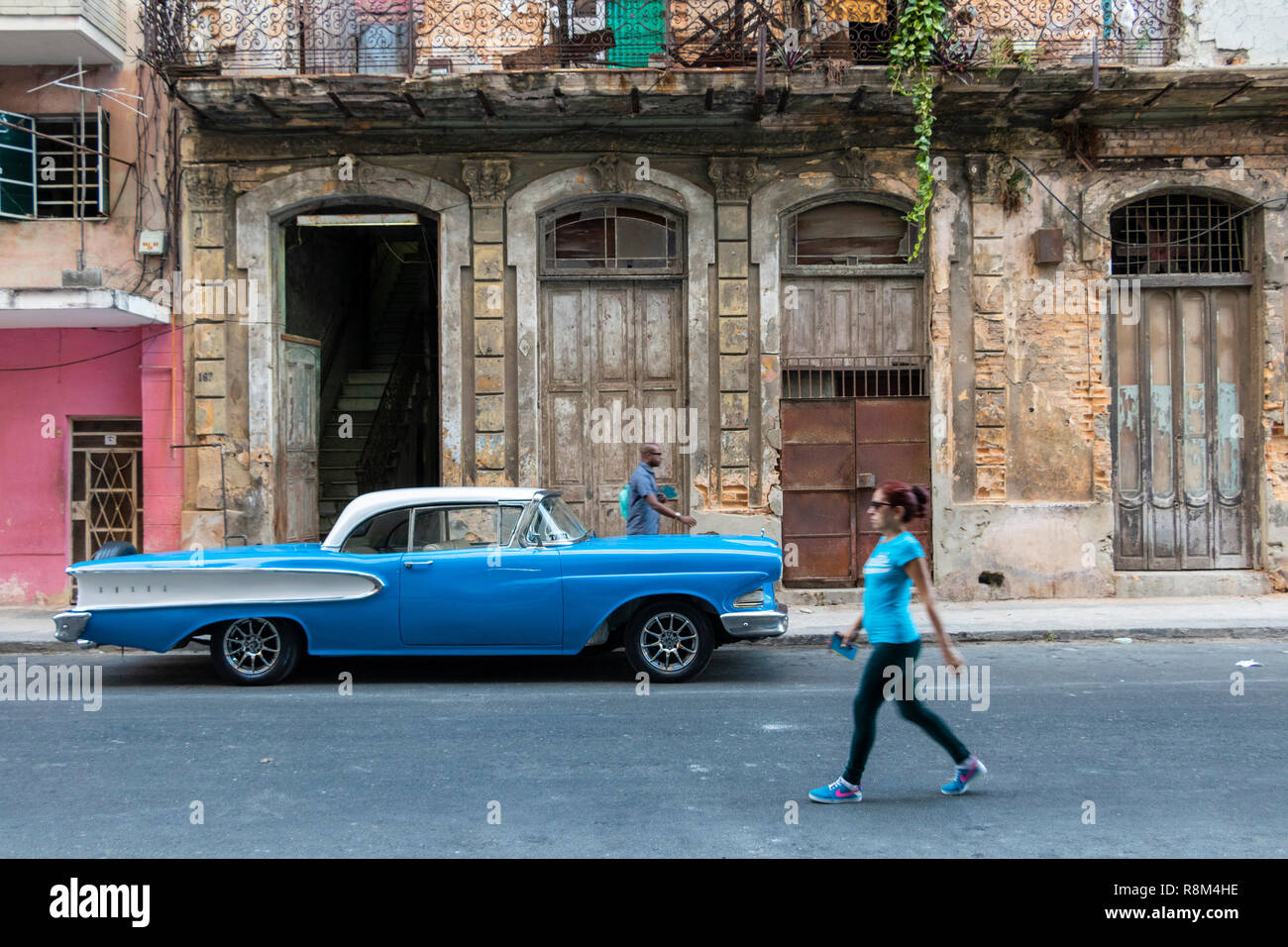 local woman walks past blue vintage 1950s American Edsel Pacer parked in Havana old town cuba Stock Photo