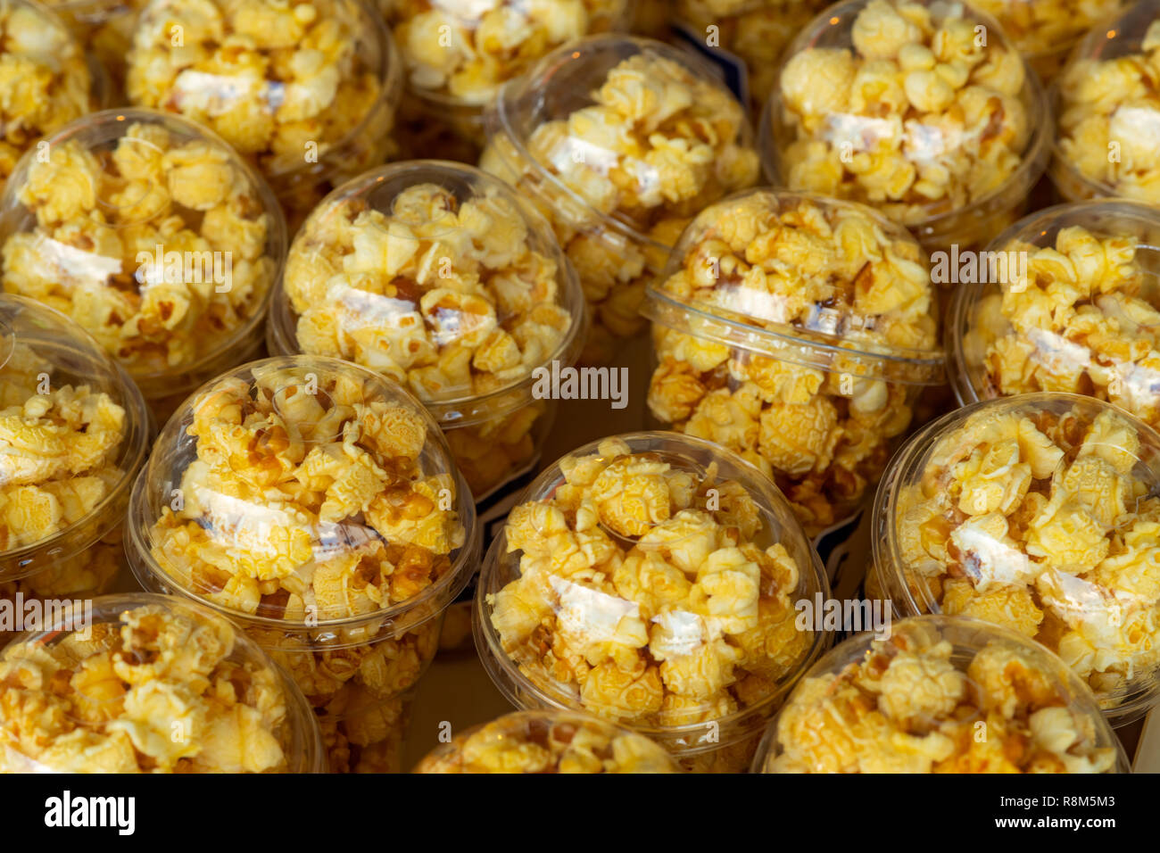 Popcorn in a plastic cup is beautifully placed. Unhealthy food or snack