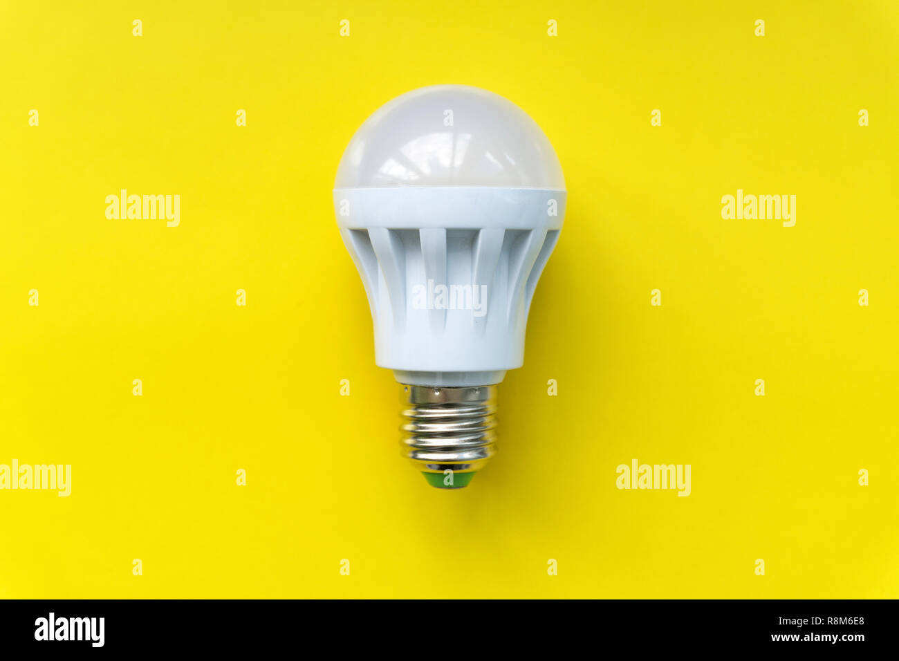 Light bulb on yellow background. Fluorescent, energy savings led lamp